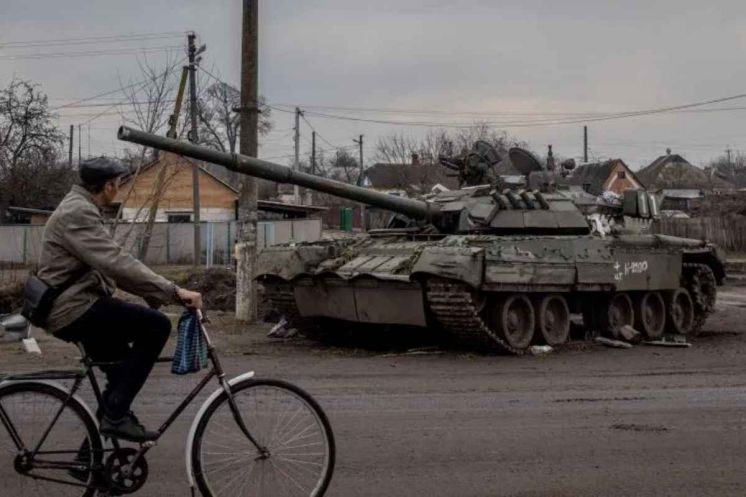 Homem passa por tanque russo destruído na cidade de Trostyanets, localizada no nordeste da Ucrânia. Foto de Chris McGrath/Getty Images